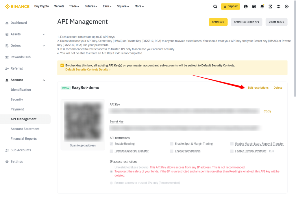 A Binance API Management page showing an API key with blurred details. A red arrow points to the “Edit restrictions” link on the right side of the screen. Various API key permissions are listed below.