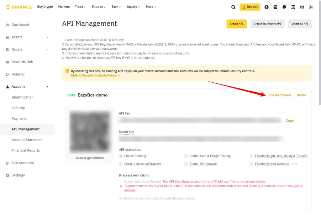 A Binance API Management page showing an API key with blurred details. A red arrow points to the “Edit restrictions” link on the right side of the screen. Various API key permissions are listed below.