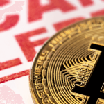 Zbliżenie złotej monety Bitcoin umieszczonej przed czerwonym ostrzeżeniem, na którym dużymi literami widnieje napis „ALERT O OSZUSTWIE”. Tło jest lekko rozmyte, co podkreśla komunikat ostrzegawczy.