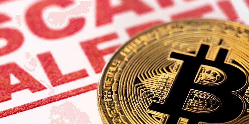 Zbliżenie złotej monety Bitcoin umieszczonej przed czerwonym ostrzeżeniem, na którym dużymi literami widnieje napis „ALERT O OSZUSTWIE”. Tło jest lekko rozmyte, co podkreśla komunikat ostrzegawczy.