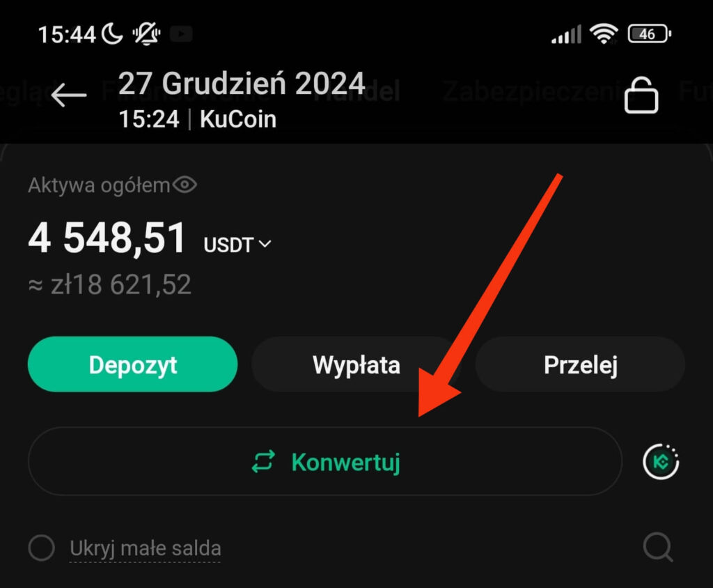 Interfejs aplikacji mobilnej wyświetlający saldo portfela kryptowalutowego wynoszące 4548,51 USDT, z opcjami wpłaty, wypłaty i przelewu. Czerwona strzałka wskazuje przycisk „Konwertuj”. Pokazana data to 27 grudnia 2024 r.